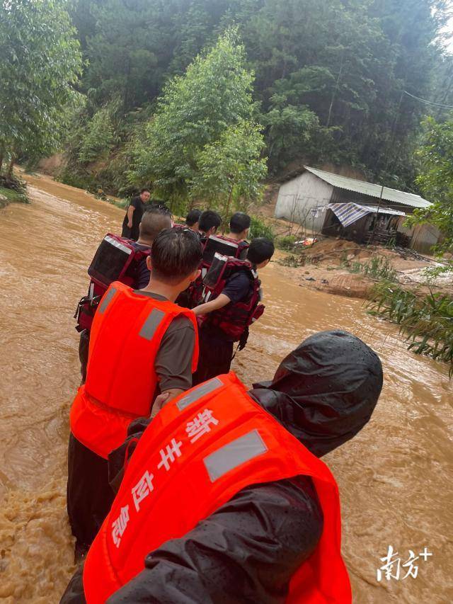 6月18日，救援人员手挽手进入来石村欧公洞村小组。受访者供图