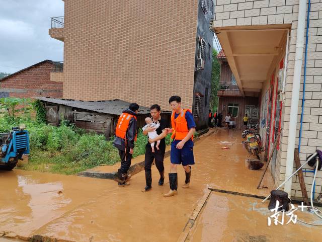 6月18日上午，韶关新丰县消防救援人员在遥田镇大埔村协助转移受灾群众。刘可宝 摄